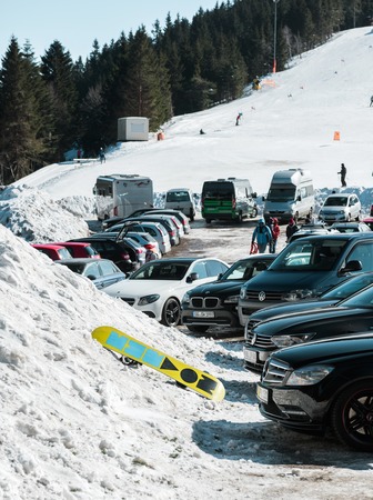 SEEBACH MUMMELSEE, FEB 25, 2018: Parking in Black Forest mountains with ski slope in background and snowboard near carsのeditorial素材