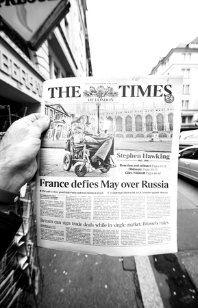 PARIS, FRANCE - MAR 15, 2018: Hand holding British newspaper The Times with portrait of Stephen Hawking the English theoretical physicist, cosmologist dead on 14 March 2018のeditorial素材