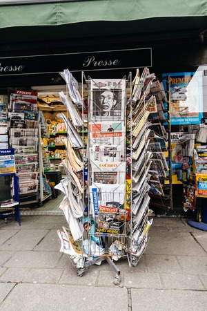 PARIS, FRANCE - MAR 15, 2018: Vertical photo International newspapes stack with portrait of Stephen Hawking the English theoretical physicist, cosmologist dead on 14 March 2018 on sale in Paris kisokのeditorial素材