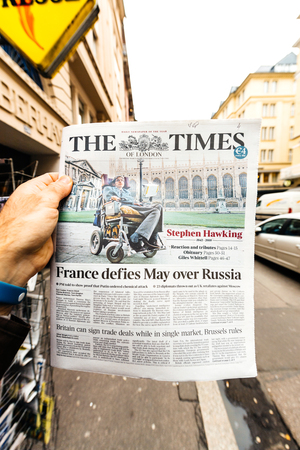 PARIS, FRANCE - MAR 15, 2018: Hand holding British newspaper The Times with portrait of Stephen Hawking the English theoretical physicist, cosmologist dead on 14 March 2018のeditorial素材