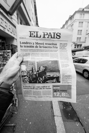 PARIS, FRANCE - MAR 15, 2018: Male hand holding Spanish El Pais newspaper with portrait of Stephen Hawking the English theoretical physicist, cosmologist dead on 14 March 2018 outdoor press kioskのeditorial素材