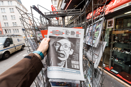 PARIS, FRANCE - MAR 15, 2018: Man buying French Liberation newspaper with portrait of Stephen Hawking the English theoretical physicist, cosmologist dead on 14 March 2018のeditorial素材