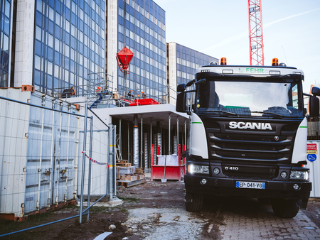 STRASBOURG, FRANCE - MAR 5, 2018: Front view of Scania G410 cement mixer truck at the reconstruction site of European Parliament and Council of Europe building in Strasbourg workers in backgroundのeditorial素材