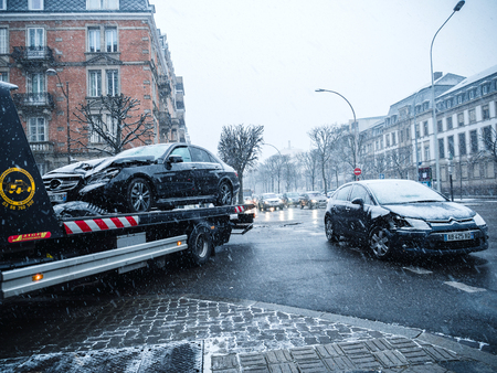 STRASBOURG, FRANCE - MAR 2, 2018: Car accident on French street between luxury limousine Mercedes-Benz and Citroen car on a snowy tempest cold day traffic jam tow truckのeditorial素材