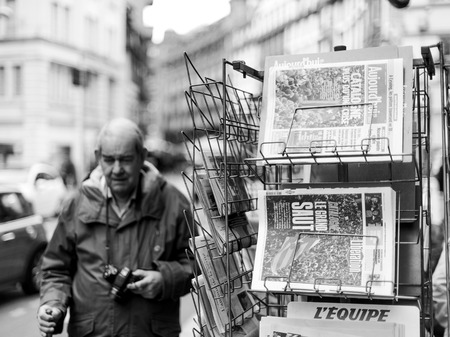 PARIS, FRANCE - OCT 28, 2017: Senior man next to french international newspaper with news from Spain about the Catalonia Referendum and protests in Barcelona - kiosk stand in cityのeditorial素材