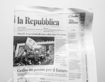 PARIS, FRANCE - MAR 19, 2017: Man reading Italian La Republica newspaper at press kiosk featuring Russian presidential election from 2018 with the winner Vladimir Putinのeditorial素材