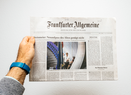 PARIS, FRANCE - MAR 15, 2017: Man reading German Frankfurter Allgemeine Zeitung newspaper at press kiosk featuring Angela Dorothea Merkel re election as Chancellor of Germanyのeditorial素材