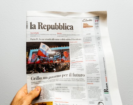 PARIS, FRANCE - MAR 19, 2017: Man reading Italian La Republica newspaper at press kiosk featuring Russian presidential election from 2018 with the winner Vladimir Putinのeditorial素材