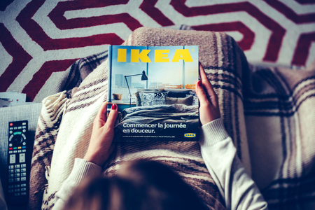 PARIS, FRANCE - AUGUST 24, 2014: View from above of woman reading IKEA Catalogue cover with living room. The catalogue is published annually by the Swedish home furnishing retailerのeditorial素材