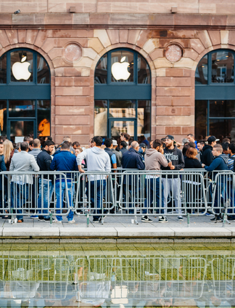 STRASBOURG, FRANCE - SEP, 19 2014: Large crowd of people in line queue in front of Apple Store with customers waiting in line to buy the latest iPhone iPad Apple Watch and notebookのeditorial素材