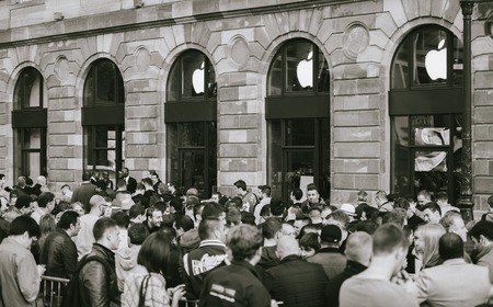 STRASBOURG, FRANCE - SEP, 19 2014: Young people in line queue in front of Apple Store with customers waiting in line to buy the latest iPhone iPad Apple Watch and notebook - black and whiteのeditorial素材