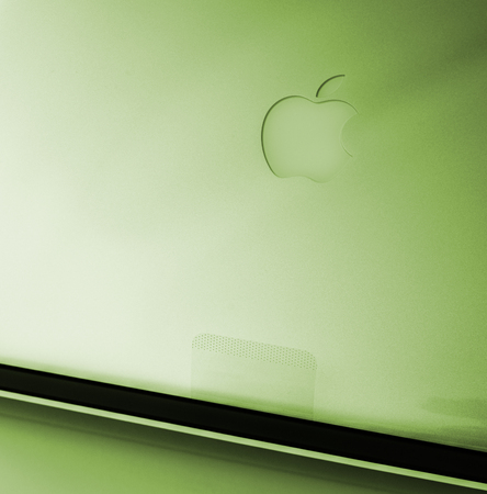 LONDON, UNITED KINGDOM - JAN 14, 2015: New Apple MacBook Pro laptop computer with fast processors and GPU unboxing with plastic film covering the laptop body and Apple logo green toneのeditorial素材