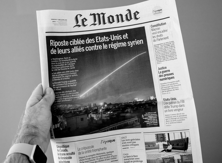 PARIS, FRANCE - APR 15, 2014: Le Monde French newspaper in man hand with cover showing Bombing Syria missle by Washington, London and Paris - black and whiteのeditorial素材
