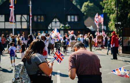 Unrecognizable couple with flags using phone on Windsor street for royal wedding marriage celebration of Prince Harry, Duke of Sussex and the Duchess of Sussex Meghan Markleの写真素材
