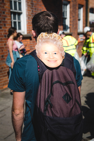WINDSOR, BERKSHIRE, UNITED KINGDOM - MAY 19, 2018: Man with masks of Queen Elizabeth II heading royal wedding marriage celebration of Prince Harry, Duke of Sussex and Duchess of Sussex Meghan Markleのeditorial素材