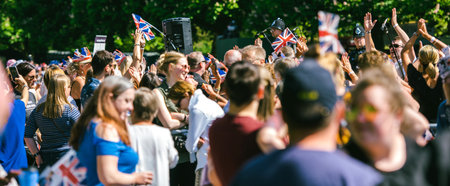 WINDSOR, , UNITED KINGDOM - MAY 19, 2018: Crowd applauding the royal wedding limousine cortege...