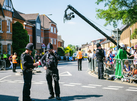 WINDSOR, UNITED KINGDOM - MAY 19, 2018: Broadcast TV camera, Constables police officers surveilling...