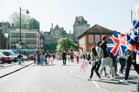 WINDSOR, UNITED KINGDOM - MAY 19, 2018: People walking to royal wedding marriage celebration of Prince Harry, Duke of Sussex and the Duchess Sussex Meghan Markle with Windsor castle in the backgroundのeditorial素材