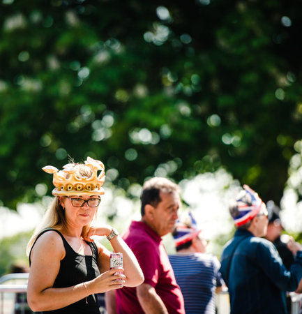 WINDSOR, UNITED KINGDOM - MAY 19, 2018: Woman with funny crown drinking beer in park at royal wedding marriage celebration of Prince Harry, Duke of Sussex and the Duchess of Sussex Meghan Markleのeditorial素材