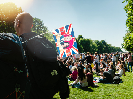 WINDSOR, BERKSHIRE, UNITED KINGDOM - MAY 19, 2018: Man with Meghan Markle and Prince Harry flag in green park of Windsor during royal wedding marriage celebrationのeditorial素材