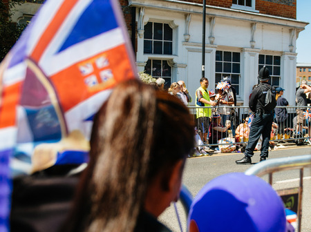 WINDSOR, BERKSHIRE, UNITED KINGDOM - MAY 19, 2018: Security police at royal wedding marriage celebration of Prince Harry and Meghan Markle seen through fansのeditorial素材
