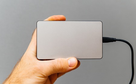 Man showing power bank for charging mobile devices also know as external battery for mobile devices such as smartphones, tablets and wearable devicesの写真素材