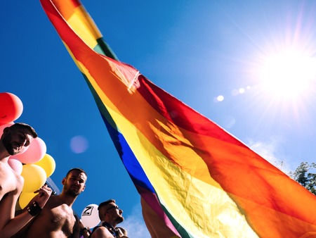 STRASBOURG, FRANCE - JUN 10, 2017: Front view of rainbow flag and caucasian excited gay men people dancing at Lesbian Gay Bisexual Transgender LGBT visibility march pride Festigaysのeditorial素材