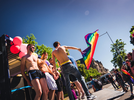 STRASBOURG, FRANCE - JUN 10, 2017: Almost naked group of excited gay men women people supporters dancing with rainbow flag behind in slow motion at Lesbian Gay Bisexual LGBT visibility march prideのeditorial素材