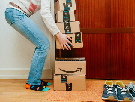 PARIS, FRANCE - JAN 13, 2018: Woman lyft the Amazon Prime packages delivered to a home doorのeditorial素材