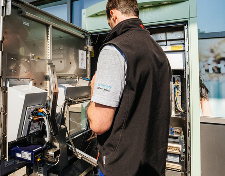 KARLSRUHE, GERMANY - MAY 11, 2018: Close-up of male operator repairing the train ticket fahrkarte service vending machine located near the entrance of the Karlsruhe Airportのeditorial素材