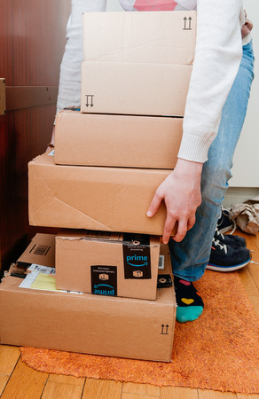 PARIS, FRANCE - JAN 13, 2018: Stack of Amazon Prime packages delivered to a home door woman preparing to unbox themのeditorial素材