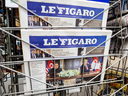 PARIS, FRANCE - JUNE 13, 2018: Man buying Le Figaro newspaper at press kiosk showing on cover  U.S. President Donald Trump meeting North Korean leader Kim Jong-un in Singaporeのeditorial素材