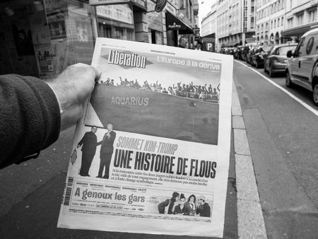 PARIS, FRANCE - JUNE 13, 2018: Man buying Liberation newspaper at press kiosk showing on cover U.S. President Donald Trump meeting North Korean leader Kim Jong-un in Singapore and Aquarius refugees boat
- black and whiteのeditorial素材