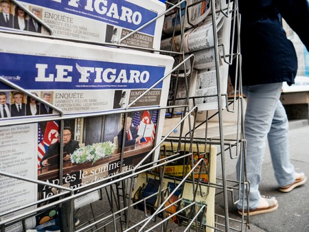 PARIS, FRANCE - JUNE 13, 2018: Man buying Le Figaro newspaper at press kiosk showing on cover  U.S. President Donald Trump meeting North Korean leader Kim Jong-un in Singaporeのeditorial素材