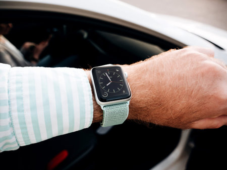 MAJORCA, SPAIN - MAY 10, 2018: Man checking time on Apple Watch before entering car - pov