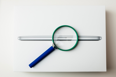 LONDON, UNITED KINGDOM - JAN 14, 2015: Loupe magnifying glass on the new Apple MacBook Pro laptop computer box with fast processors and GPU unboxingのeditorial素材