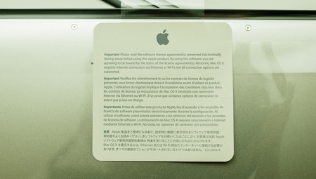 LONDON, UNITED KINGDOM - JAN 14, 2015: New Apple MacBook Pro laptop computer with fast processors and GPU unboxing with plastic film of Software License Agreement sticker - green castのeditorial素材