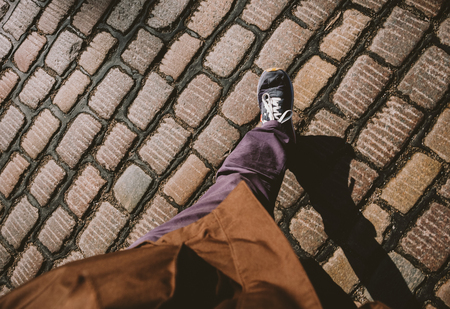 Man feets POV walking on the cobblestone paved roads of Hamburgの写真素材
