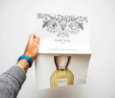 PARIS, FRANCE - MAR 19, 2018: man holding against white background advertising poster from Anaik Goutal perfumes with the latest creationのeditorial素材
