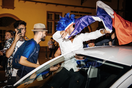 STRASBOURG, FRANCE - JULY 10, 2018: Man waving France flag from car Unique French celebration after the victory of France qualify for the final of the 2018 FIFA World Cup after their victoryのeditorial素材