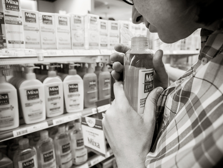 PARIS, FRANCE - JUN 23, 2018: Woman shopping diverse cosmetics and healthcare medical products in beauty pharmacie supermarket in France Cicabiafine - Micellar milk blacak and whiteのeditorial素材