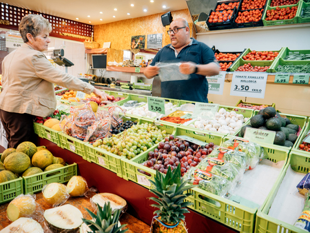FELANITX, PALMA DE MAJORCA, SPAIN - MAY 10, 2018: Spanish senior woman buying fruits and vegetables on the local farmers market in central squareのeditorial素材
