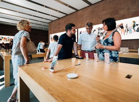 PARIS, FRANCE - JUL 16, 2018: Modern Apple Mac store main hall with Genius employee explaining to couple about iPhone Xのeditorial素材