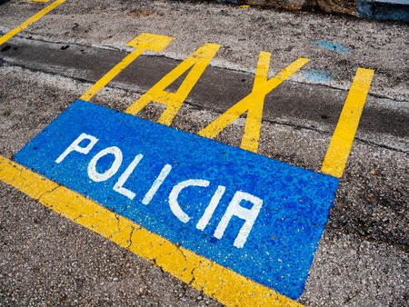 Yellow Taxi and blue Policia parking signs on the asphalt in the spanish city of Palma de Mallorcaの写真素材