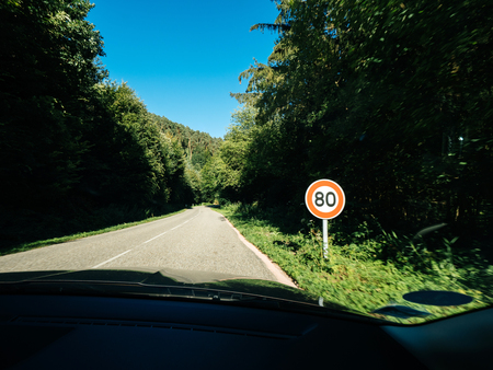 New French 80kmph speed limit sing seen on a public road in the forest.の写真素材