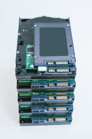 Elevated view of multiple HDD hard disk drives with modern fast SSD solid state drive placed above...