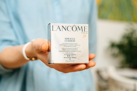 PARIS, FRANCE - AUG 2, 2018: Woman holding in hand miracle cushion from Lancome Cosmetics all-in-one liquid compact foundation & refillsのeditorial素材