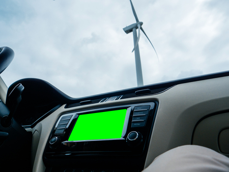 View from the car of large infotainment GPS dashboard system and large wind power station - Netherlands - green chroma screenの写真素材