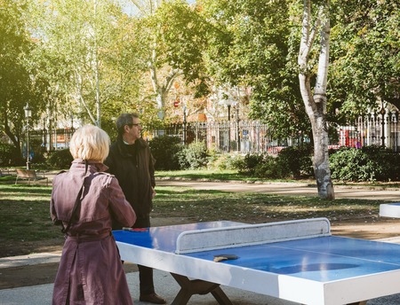 BARCELONA, SPAIN - OCT 11, 2017: Senior man and woman in park preparing to play table tennis game in sunlight Ciutadella Parkのeditorial素材