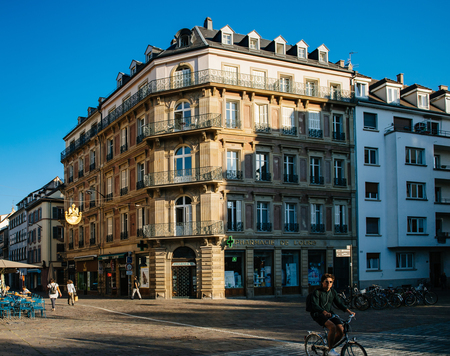 STRASBOURG, FRANCE - SEP 12, 2018: Place dAusterlitz with French pharmacy, bars, and traditional French architecture buildingsのeditorial素材